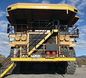 Front view of a CAT off-highway mining truck on a haul road.