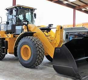 CAT wheel loader with bucket lowered inside a workshop.